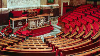 De lege vergaderzaal van de Franse Assemblée nationale in Parijs, met rode zetels.