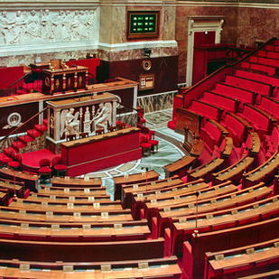De lege vergaderzaal van de Franse Assemblée nationale in Parijs, met rode zetels.